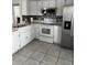 Kitchen with white cabinets, tile floors, and stainless steel appliances at 378 Southern Charm Dr, Orlando, FL 32807
