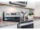 Modern kitchen features a sleek stovetop and oven, granite countertops, and stainless steel appliances at 418 St Johns Ln, Kissimmee, FL 34759