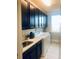 Bright laundry room with white appliances and dark cabinets at 9859 Winnington St, Orlando, FL 32832