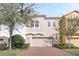 Tan three-story townhome with two-car garage and landscaped front yard at 15241 Sunrise Grove Ct, Winter Garden, FL 34787