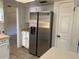 Stainless steel refrigerator in kitchen with white cabinets and tiled floor at 496 Raymond Ave, Longwood, FL 32750