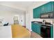 Small kitchen with teal cabinets and black appliances at 7383 Universal Blvd # 512, Orlando, FL 32819