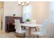 Bright dining area with white table and chairs, piano, and natural light at 4569 Storytelling Way, Kissimmee, FL 34746