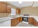 Kitchen area with wood cabinets, white countertops, and appliances at 1084 Villa Ln # 72, Apopka, FL 32712