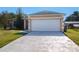 Tan house with white garage door and spacious driveway at 1110 Seminole Dr, Kissimmee, FL 34744