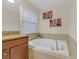 Relaxing bathroom with a large soaking tub and window at 2948 Banana Palm Dr, Kissimmee, FL 34747