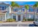 Light blue townhome with dark brown accents, landscaping, and parking at 3205 Gold Ln, Kissimmee, FL 34747