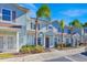 Two-story light blue townhome with palm trees and parking spaces at 3205 Gold Ln, Kissimmee, FL 34747