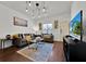 Living room with gray sectional sofa, large TV, and wood floors at 3205 Gold Ln, Kissimmee, FL 34747