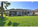 Large backyard with screened patio and lush lawn at 3555 Maribella Dr, New Smyrna Beach, FL 32168