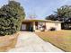 House exterior with covered entry and mature landscaping at 1403 Amaros Ave, Orlando, FL 32811