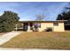 Tan single story house with grassy yard and driveway at 1403 Amaros Ave, Orlando, FL 32811