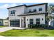 Modern two-story house with a white exterior, gray driveway, and lush landscaping at 1606 Hart Ln, Orlando, FL 32804