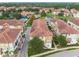 Aerial view of community with resort-style pool, tennis courts, and Spanish-style architecture at 1801 Lobelia Dr, Lake Mary, FL 32746