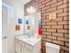 Small bathroom with a white vanity and brick-patterned walls at 2477 Shanti Dr, Kissimmee, FL 34746