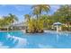 Sparkling community pool surrounded by lush tropical plants at 5368 Diplomat Ct # 104, Kissimmee, FL 34746