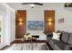 Living room features wood-look floors, a gray sofa, and a modern media wall at 5368 Diplomat Ct # 104, Kissimmee, FL 34746