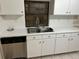 White kitchen cabinets, stainless steel dishwasher, and double sink at 602 Mesilla Dr, Kissimmee, FL 34758