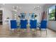 Elegant dining room with glass table and blue chairs at 7423 Sparkling Ct, Reunion, FL 34747