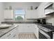 Modern kitchen with white cabinets and granite countertops at 7423 Sparkling Ct, Reunion, FL 34747
