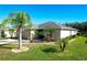 One-story home with a two-car garage, palm trees, and green lawn at 149 Springberry Ct, Daytona Beach, FL 32124