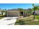 Tan, single-story home with attached two-car garage and landscaped yard at 149 Springberry Ct, Daytona Beach, FL 32124