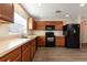 Well-appointed kitchen with wood cabinets, black appliances, and laminate flooring at 149 Springberry Ct, Daytona Beach, FL 32124