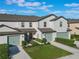 Two-story townhouse with light-colored siding and green garage doors at 1592 Wynford Cir, Tavares, FL 32778
