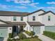 Townhouse exterior with two-car garage and well-manicured lawn at 1592 Wynford Cir, Tavares, FL 32778