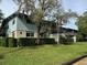Building exterior, showing a light teal building with trees and a fence at 1695 Lee Rd # B216, Winter Park, FL 32789