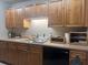 Kitchen featuring wood cabinets, black appliances, and a double sink at 1695 Lee Rd # B216, Winter Park, FL 32789