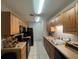 A galley-style kitchen with wood cabinets and black appliances at 1695 Lee Rd # B216, Winter Park, FL 32789