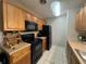 Kitchen with wood cabinets, black appliances, and ample counter space at 1695 Lee Rd # B216, Winter Park, FL 32789