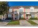 Two-story townhome with a light tan exterior and landscaping at 2361 Silver Palm Dr, Kissimmee, FL 34747