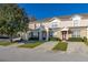 Two-story townhome with a light tan exterior and landscaping at 2361 Silver Palm Dr, Kissimmee, FL 34747
