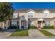 Tan two-story townhome with dark brown doors and landscaping at 2361 Silver Palm Dr, Kissimmee, FL 34747