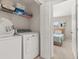 Bright laundry room with washer, dryer, and shelving for storage at 2361 Silver Palm Dr, Kissimmee, FL 34747