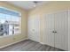 Bedroom with a large window, double door closets, and wood-look floors at 7135 Yacht Basin Ave # 237, Orlando, FL 32835