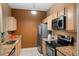 Galley kitchen with granite counters and stainless steel appliances at 7135 Yacht Basin Ave # 237, Orlando, FL 32835