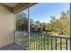 Screened balcony overlooks a grassy courtyard with trees and neighboring buildings at 7135 Yacht Basin Ave # 237, Orlando, FL 32835
