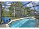 Screened-in pool with blue lounge chairs and a spa at 8939 Coconut Breeze Dr, Kissimmee, FL 34747