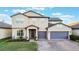 Two-story house with gray siding, purple garage doors, and a landscaped lawn at 2609 Mead Ave, St Cloud, FL 34771