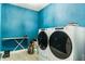 Laundry room with Whirlpool washer and dryer, ironing board, and blue walls at 2609 Mead Ave, St Cloud, FL 34771