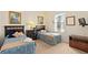 Guest bedroom with two twin beds, nightstand and media console at 404 Brunello Dr, Davenport, FL 33897