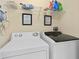 Laundry room with washer, dryer, and storage shelves at 404 Brunello Dr, Davenport, FL 33897