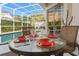 Screened patio with table set for four overlooking pool at 404 Brunello Dr, Davenport, FL 33897