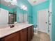 Bathroom with teal walls, double vanity, and walk-in shower at 610 Aeolian Dr, New Smyrna Beach, FL 32168
