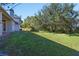 Landscaped backyard with green grass and a partial view of the house at 1178 Black Walnut Ct, Winter Springs, FL 32708