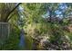 Peaceful creek bordered by lush vegetation and a fence at 1178 Black Walnut Ct, Winter Springs, FL 32708