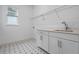 Laundry room with white cabinets, a sink, and patterned tile floor at 15086 Summer Harvest St, Winter Garden, FL 34787